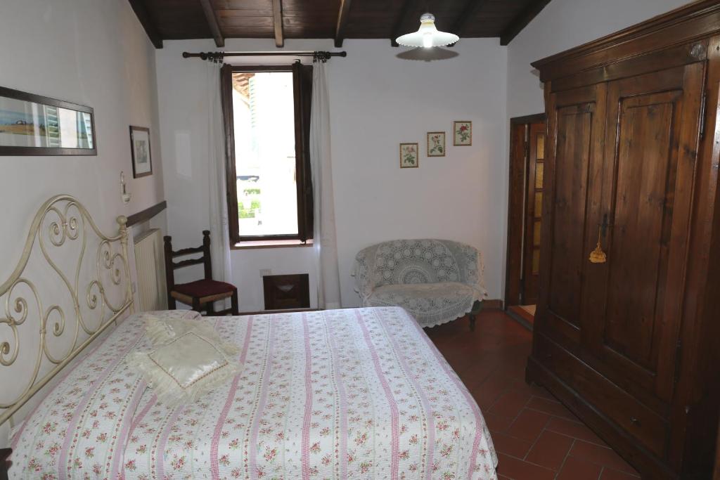 a bedroom with a bed and a chair and a window at Apartment Piazza Matteotti in Greve in Chianti