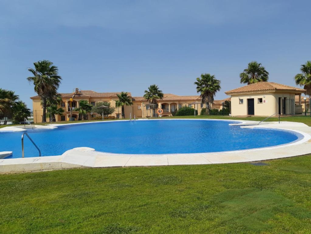 a large swimming pool in a yard with a house at El Mirador del Coto in Sanlúcar de Barrameda