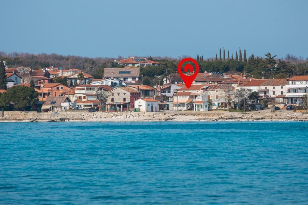 una cometa de corazón rojo volando sobre el agua junto a una ciudad en Apartments by the sea Zambratija, Umag - 2557, en Zambratija