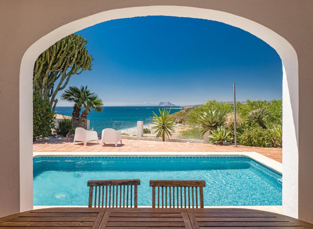- une piscine avec 2 chaises et l'océan dans l'établissement San Diego PANORAMIC VIEW 2393, à San Roque