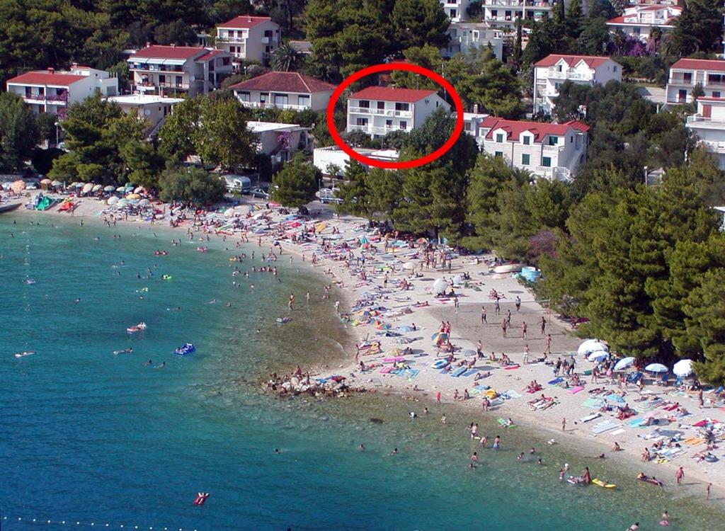un groupe de personnes sur une plage avec un cercle rouge dans l'établissement Apartments and rooms by the sea Baska Voda, Makarska - 2578, à Baška Voda