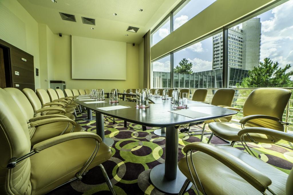 a conference room with tables and chairs and a screen at Flamingo Grand Hotel & Spa in Albena