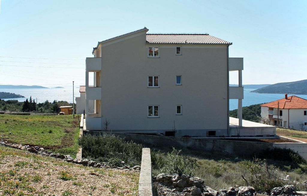 um grande edifício branco no topo de uma colina em Apartments with WiFi Seget Vranjica, Trogir - 4870 em Trogir