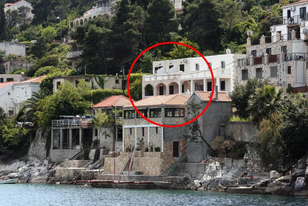 a large house on the water with a red circle at Apartments by the sea Sobra, Mljet - 4889 in Babino Polje