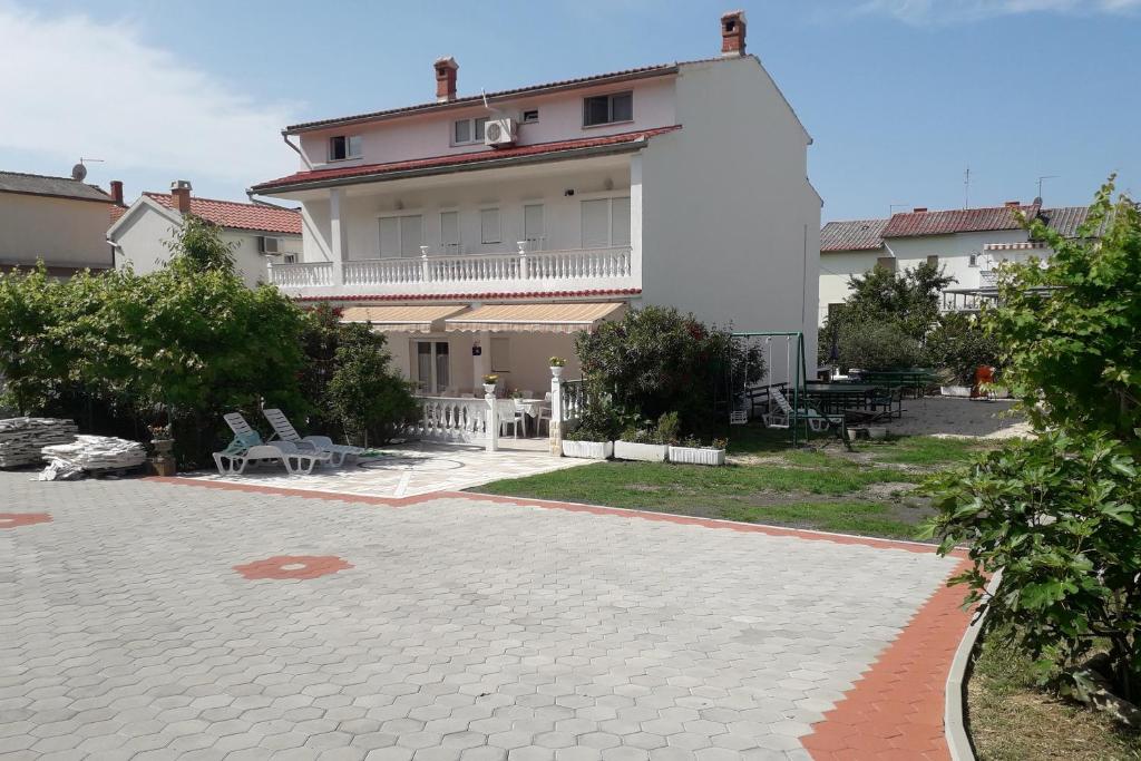 a large white building with a patio in front of it at Apartments with a parking space Palit, Rab - 4990 in Rab