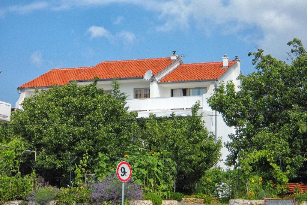 a white house with an orange roof at Apartments with a parking space Palit, Rab - 4971 in Rab