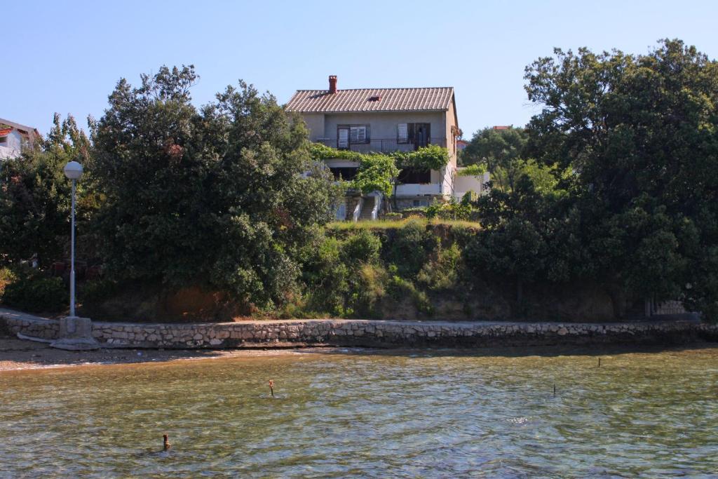 a house on the shore of a body of water at Apartments by the sea Supetarska Draga - Gonar, Rab - 4989 in Supetarska Draga