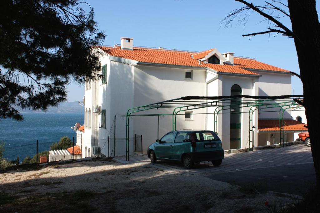 a small car parked in front of a building at Apartments by the sea Balica Rat, Omis - 4868 in Čelina