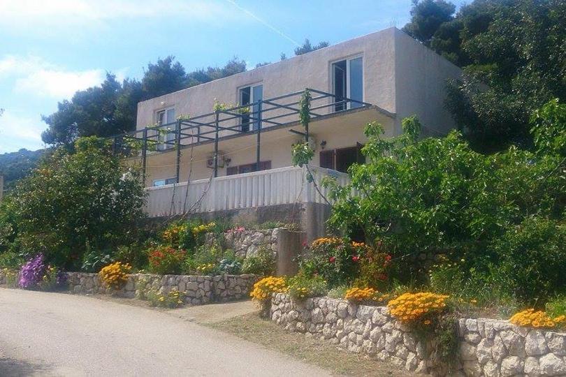 uma casa ao lado de uma estrada com flores em Apartments and rooms by the sea Cove Saplunara, Mljet - 4907 em Saplunara