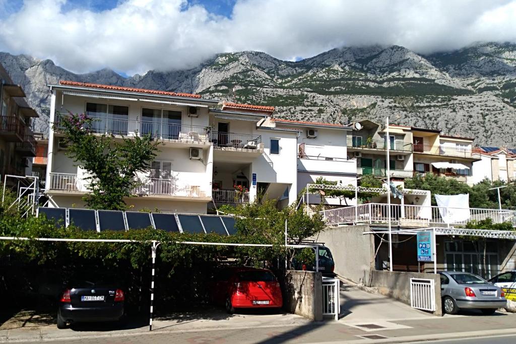 馬卡爾斯卡的住宿－Apartments with a parking space Makarska - 6784，一座有汽车停放在停车场的山间建筑