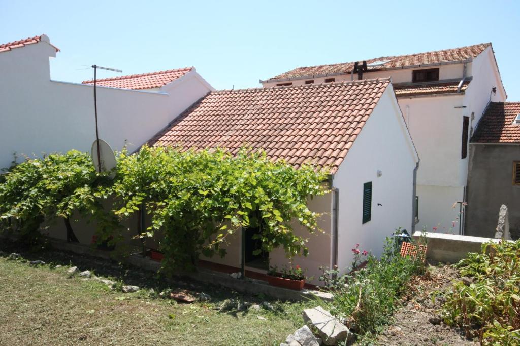 Ein weißes Haus mit einem Haufen Reben in der Unterkunft Apartments by the sea Zaostrog, Makarska - 6659 in Zaostrog
