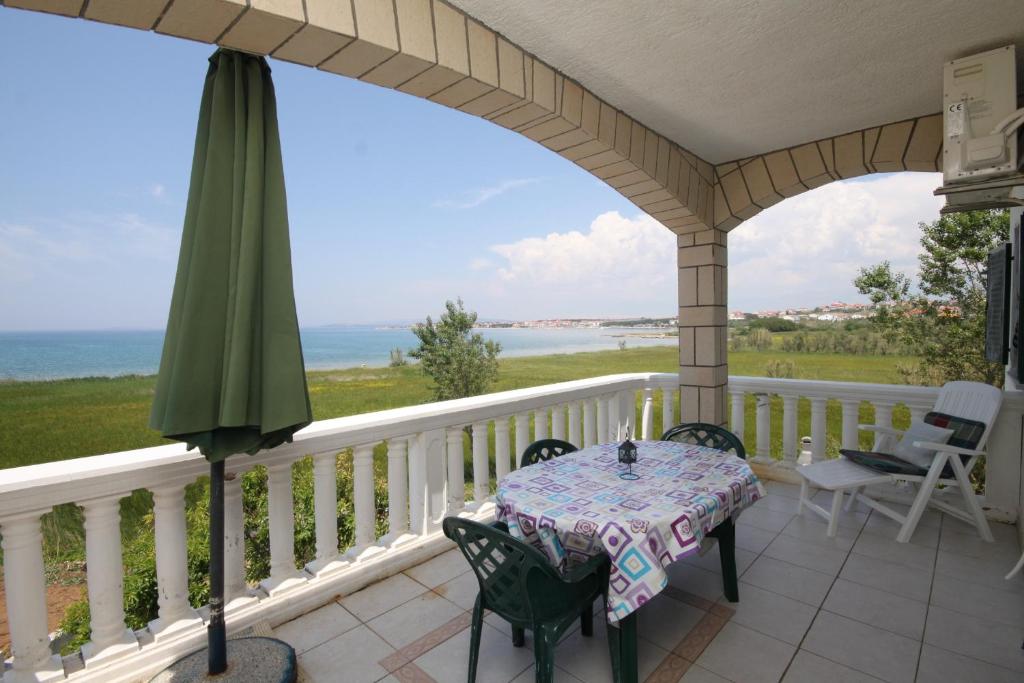 weranda ze stołem i krzesłami oraz oceanem w obiekcie Apartments by the sea Povljana, Pag - 6502 w mieście Povljana