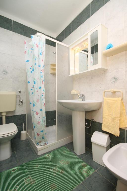 łazienka z umywalką, toaletą i prysznicem w obiekcie Apartments by the sea Povljana, Pag - 6502 w mieście Povljana