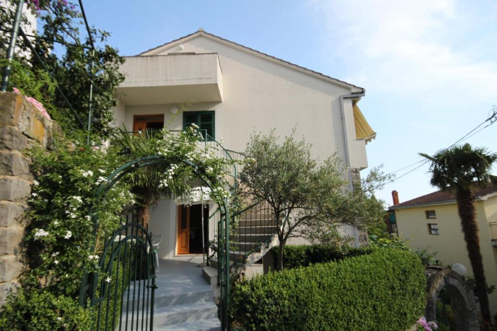uma casa branca com um portão e arbustos em Apartments by the sea Podgora, Makarska - 6664 em Podgora