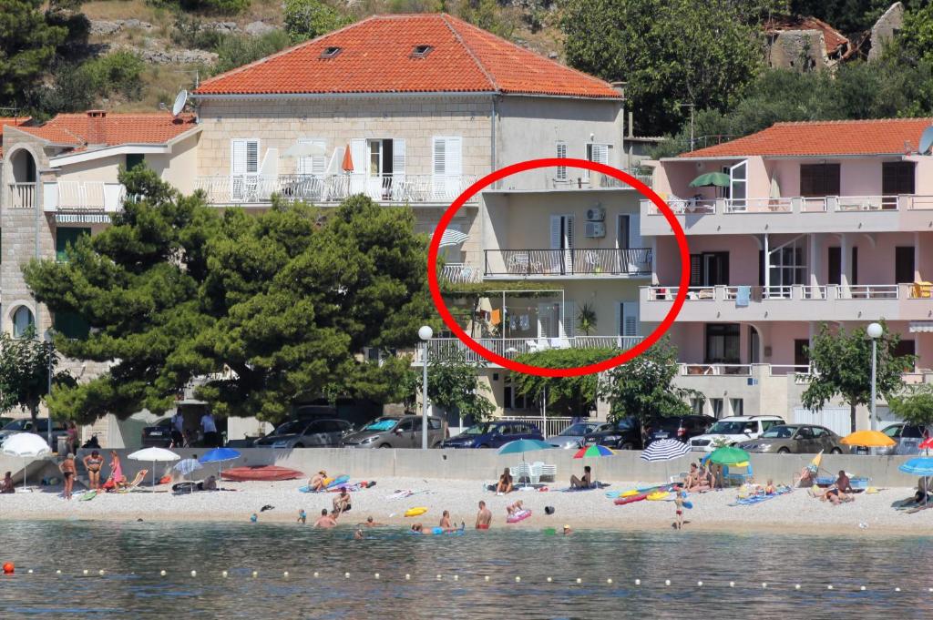 um grupo de pessoas numa praia perto da água em Apartments by the sea Podgora, Makarska - 6780 em Podgora