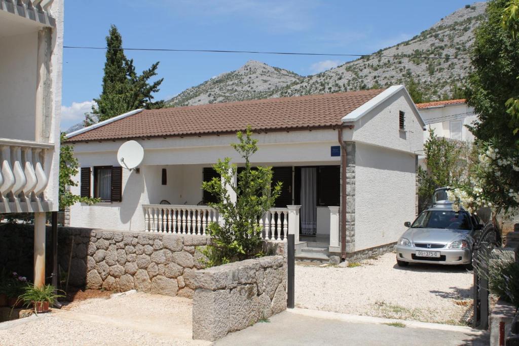 a house with a car parked in front of it at Apartments with a parking space Starigrad, Paklenica - 6566 in Starigrad