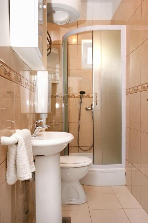 łazienka z toaletą, umywalką i prysznicem w obiekcie Apartments by the sea Pag - 6448 w mieście Pag