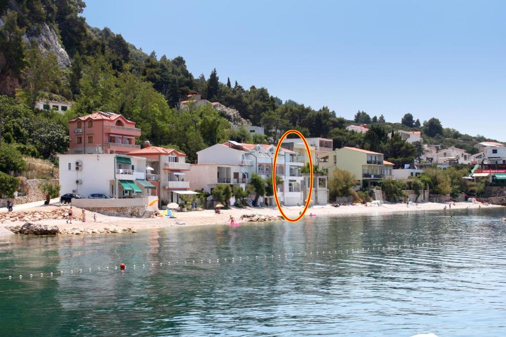 德拉辛歇的住宿－Apartments by the sea Drasnice, Makarska - 6652，海滩旁的水中的一个橙色物体