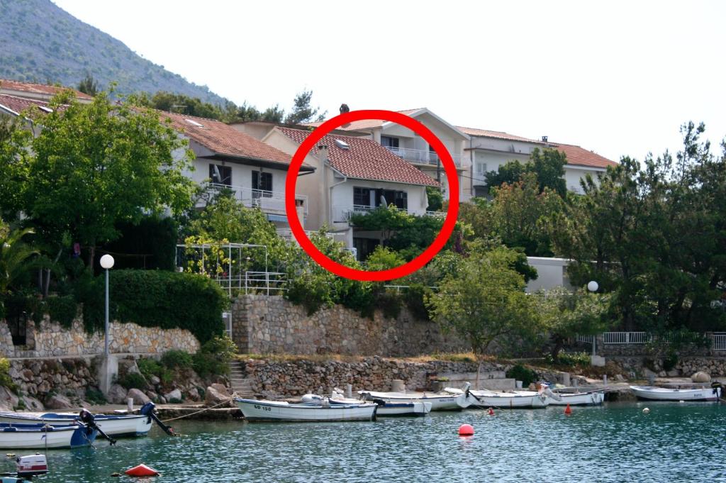 grupa łodzi w wodzie przed domem w obiekcie Apartments by the sea Starigrad, Paklenica - 6589 w mieście Starigrad-Paklenica