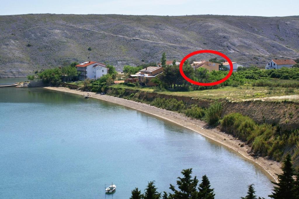 łódź w rzece z czerwonym krągiem w obiekcie Apartments by the sea Vlasici, Pag - 6523 w mieście Povljana