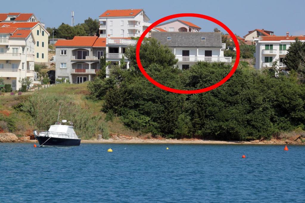 un bateau dans l'eau avec un cercle rouge dans l'établissement Apartments and rooms by the sea Povljana, Pag - 6476, à Povljana