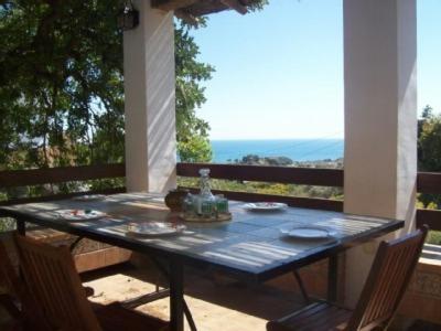 una mesa en un porche con vistas al océano en La Haza, en Frigiliana