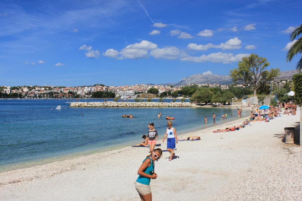 a group of people on a beach near the water at Apartments by the sea Podstrana, Split - 9714 in Podstrana