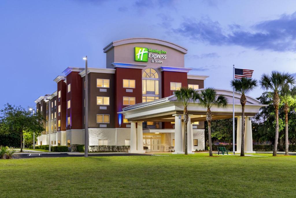 Holiday Inn Express Hotel & Suites Fort Pierce West, an IHG Hotel في فورت بييرس: مبنى الفندق وامامه حديقة