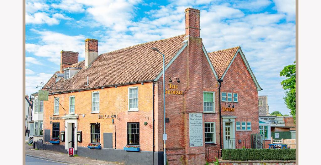 an old brick building on the corner of a street at The George Hotel, Dereham in East Dereham