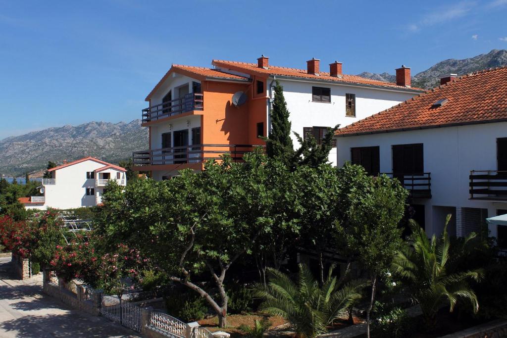 a group of buildings with trees and bushes at Apartments and rooms by the sea Starigrad, Paklenica - 6591 in Starigrad