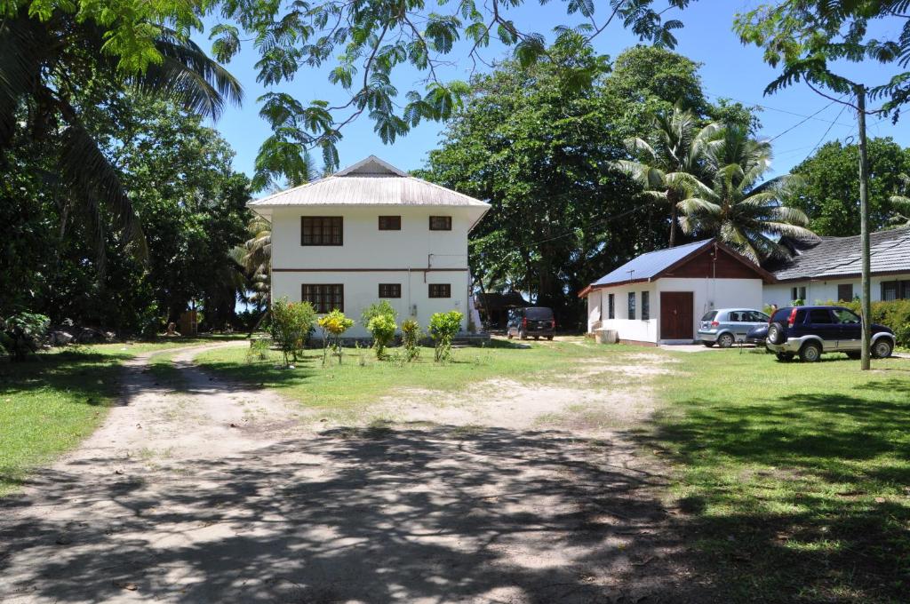 uma casa com uma estrada de terra em frente em La Colombe D'Or em Grand'Anse Praslin