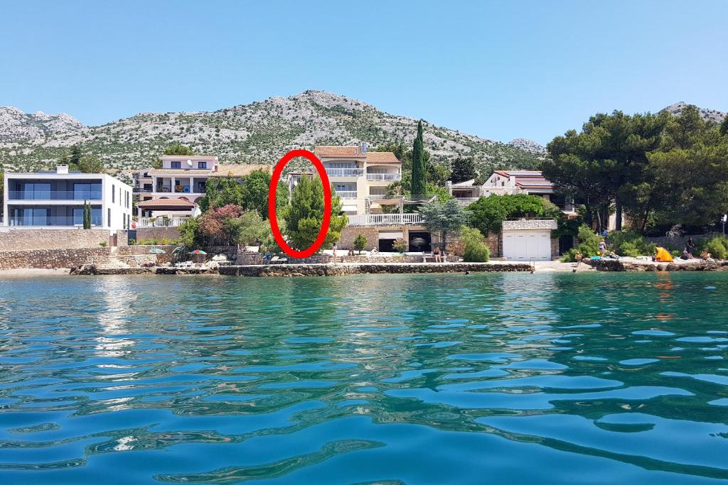 a red circle is sitting on the water at Apartments by the sea Starigrad, Paklenica - 6621 in Starigrad