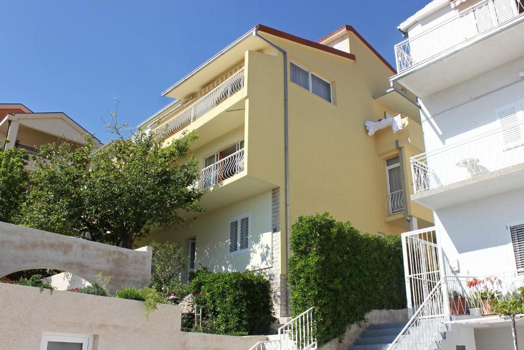 un bâtiment jaune avec des appartements blancs dans l'établissement Apartments and rooms with parking space Makarska - 6767, à Makarska