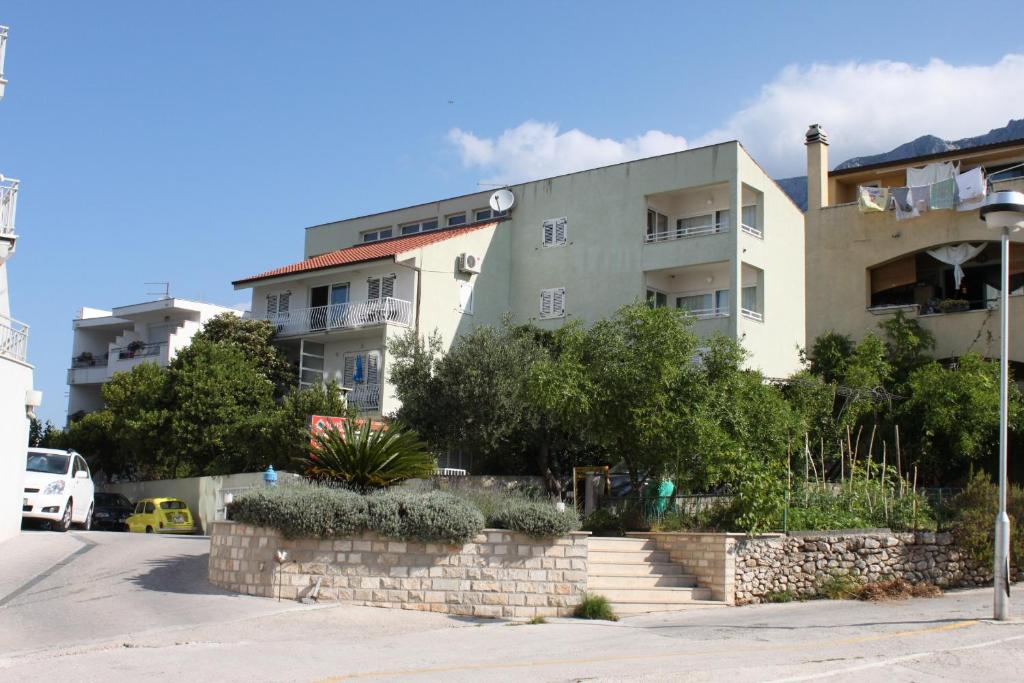 a building with a staircase in front of it at Apartments and rooms by the sea Makarska - 6839 in Makarska