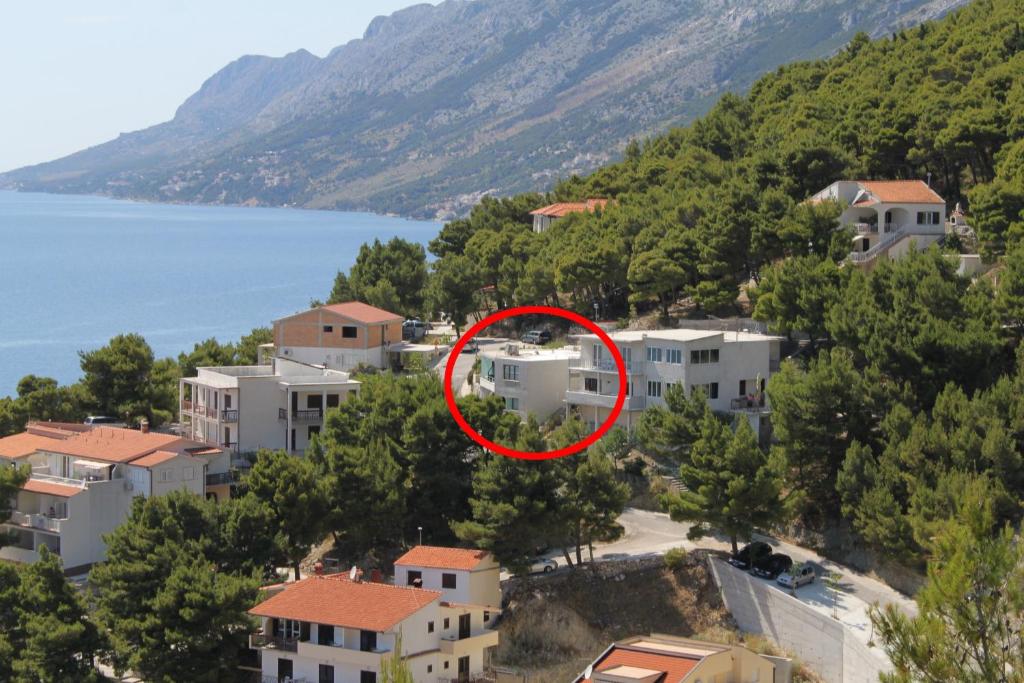 a house with a red circle in the middle of a city at Apartments with a parking space Brela, Makarska - 6907 in Brela