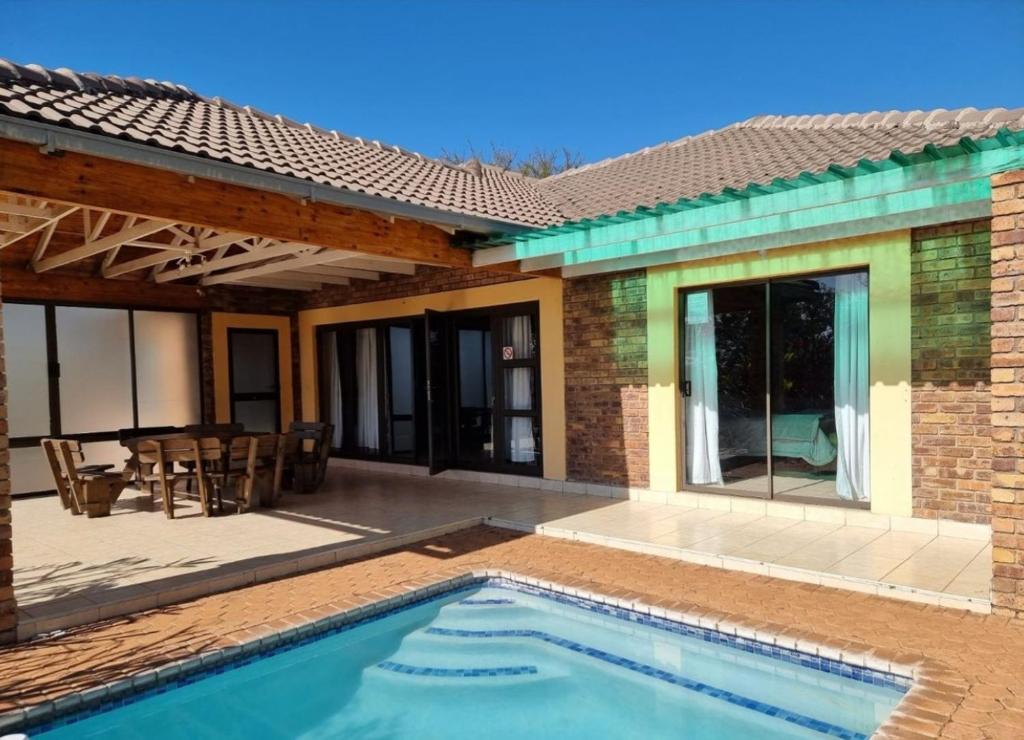 a house with a swimming pool and a patio at Hide Away Wedding,Conference & Function Venue in Bela-Bela