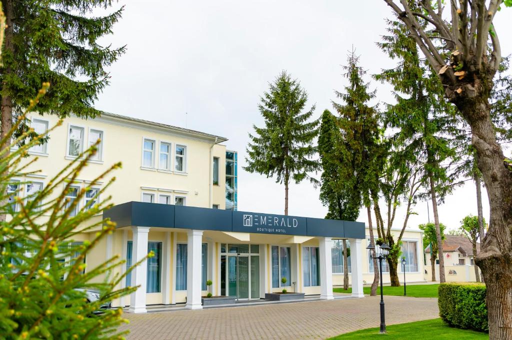 a white building with a sign that reads peland at Emerald Boutique Hotel in Târgu-Mureş