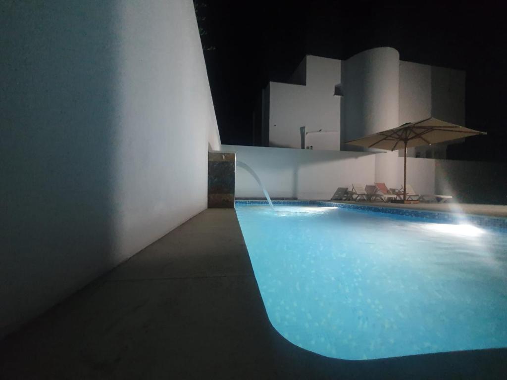 una piscina por la noche con sombrilla en Villa de luxe avec piscine sans vis à vis Midoun, en Aghīr