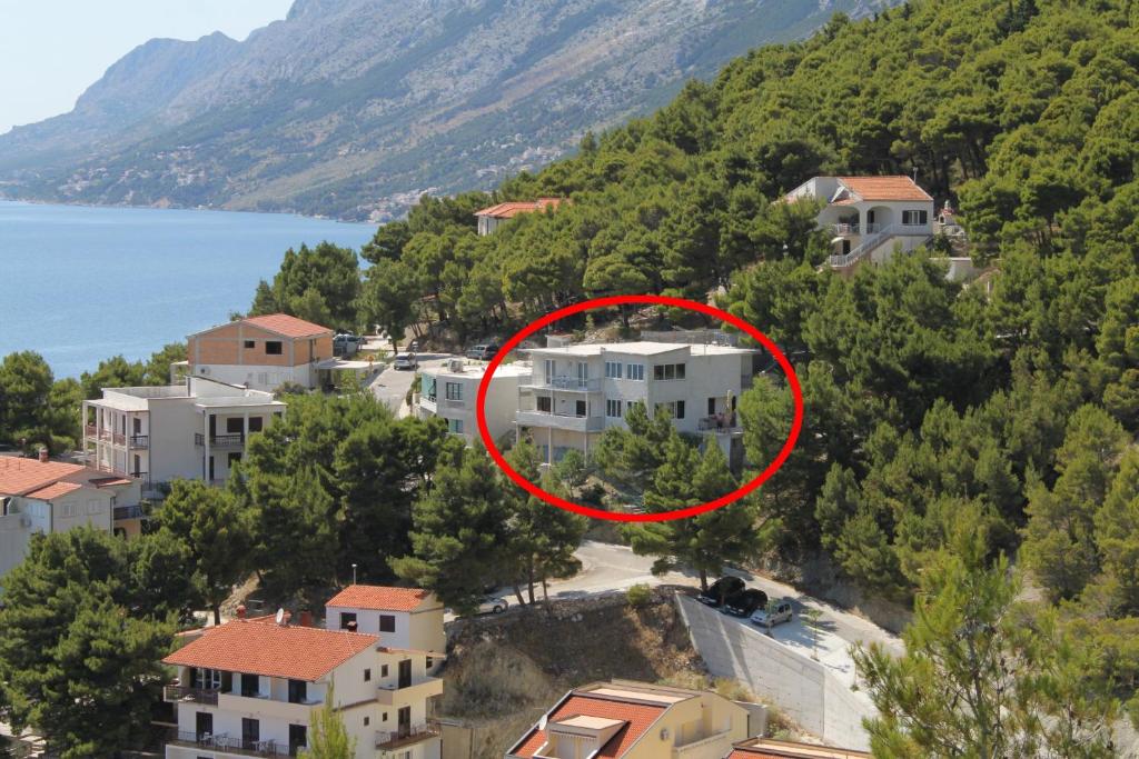 una casa en una colina con un círculo rojo en Apartments and rooms with parking space Brela, Makarska - 6895 en Brela