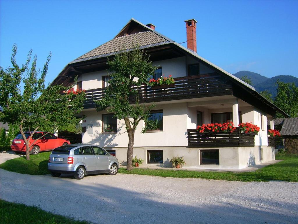 ein Haus mit einem davor geparkt in der Unterkunft Apartments Žnidar in Bohinj