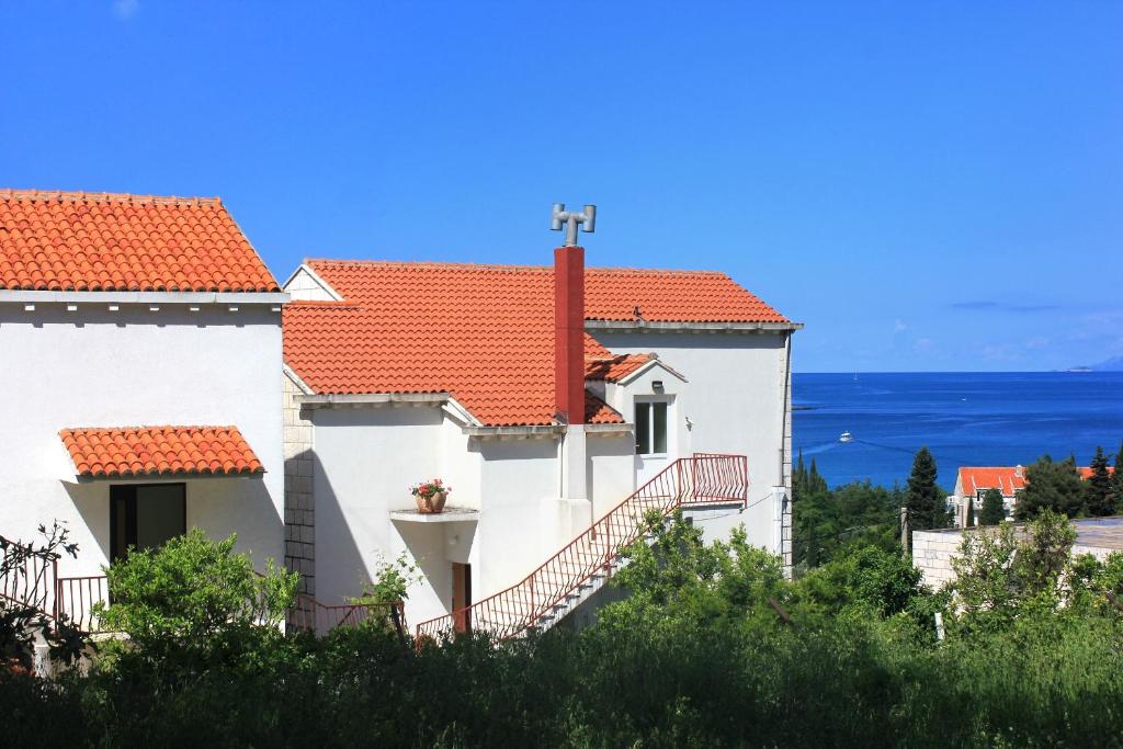 a white house with red roofs and the ocean at Rooms with a swimming pool Cavtat, Dubrovnik - 5222 in Cavtat