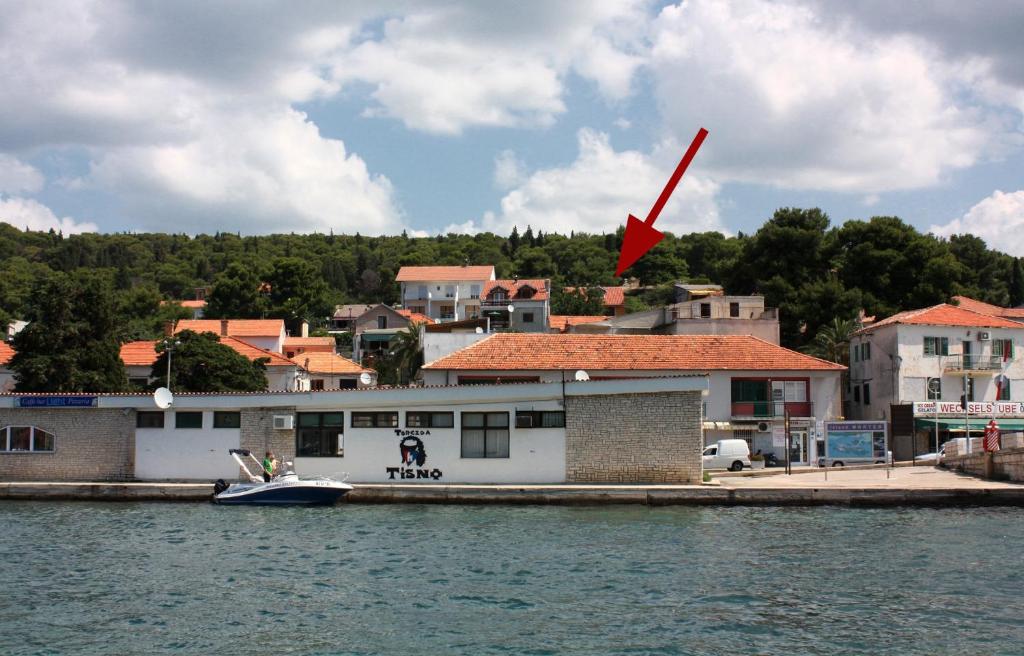 um barco está ancorado numa doca na água em Seaside holiday house Tisno, Murter - 5094 em Tisno