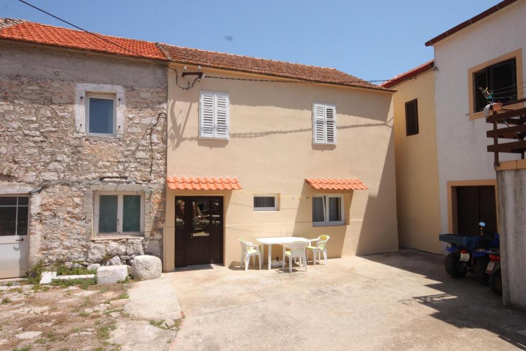 a patio in front of a house with a table and chairs at Holiday house with a parking space Sali, Dugi otok - 8138 in Sali