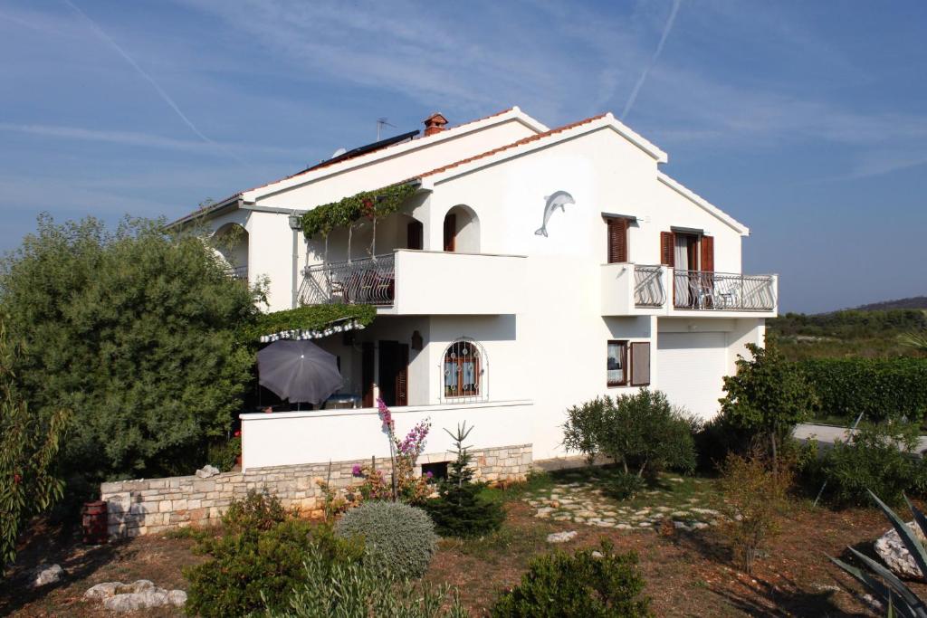 a white house on a hill with bushes at Rooms with a parking space Gornje selo, Solta - 5170 in Grohote