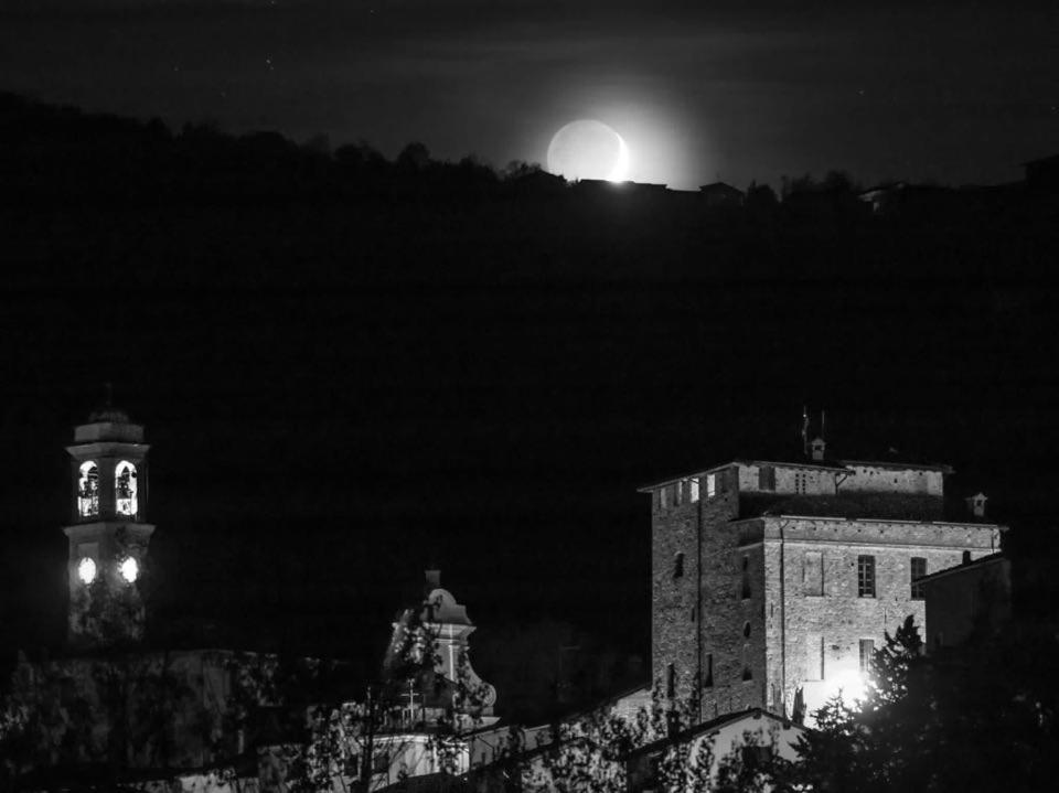 a night view of a building and a clock tower at Cozy & Good Vibes Villa Castana. in Romagnese