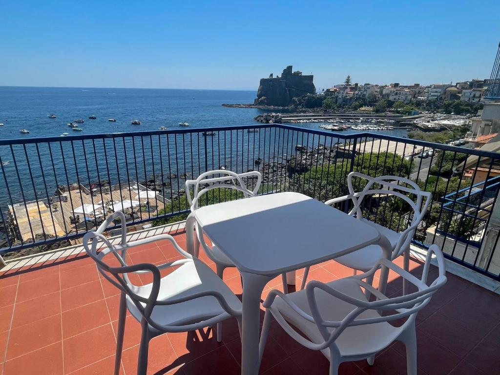 a table and chairs on a balcony overlooking the ocean at Mareincasa in Aci Castello