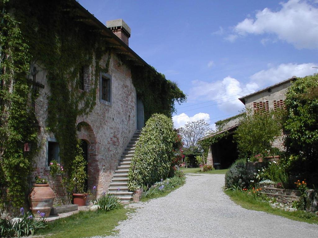 a stone building with stairs and ivy on it at Agriturismo Poggio ai Grilli in Gambassi Terme