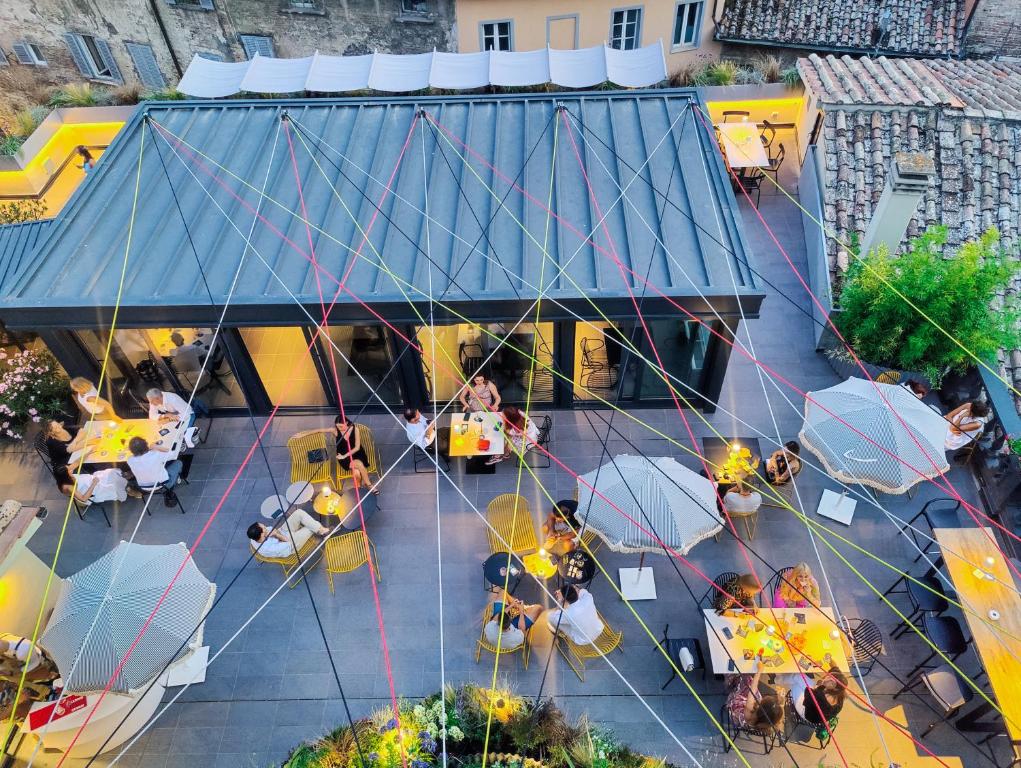 una vista panoramica su un ristorante con tavoli e ombrelloni di Hotel Priori Secret Garden a Perugia
