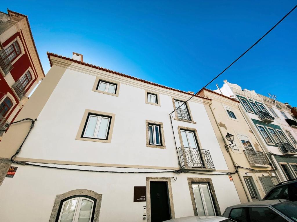 a tall white building with a black door at Concha Setúbal Miradouro in Setúbal