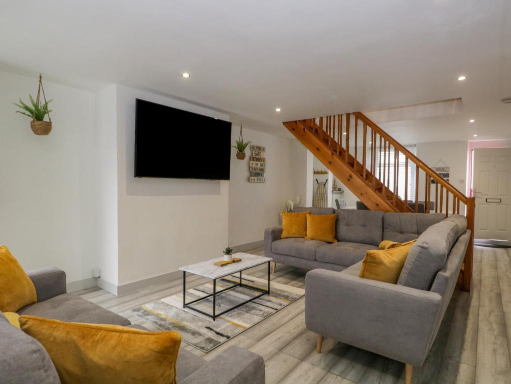 a living room with two couches and a flat screen tv at Harbour Retreat in Millom